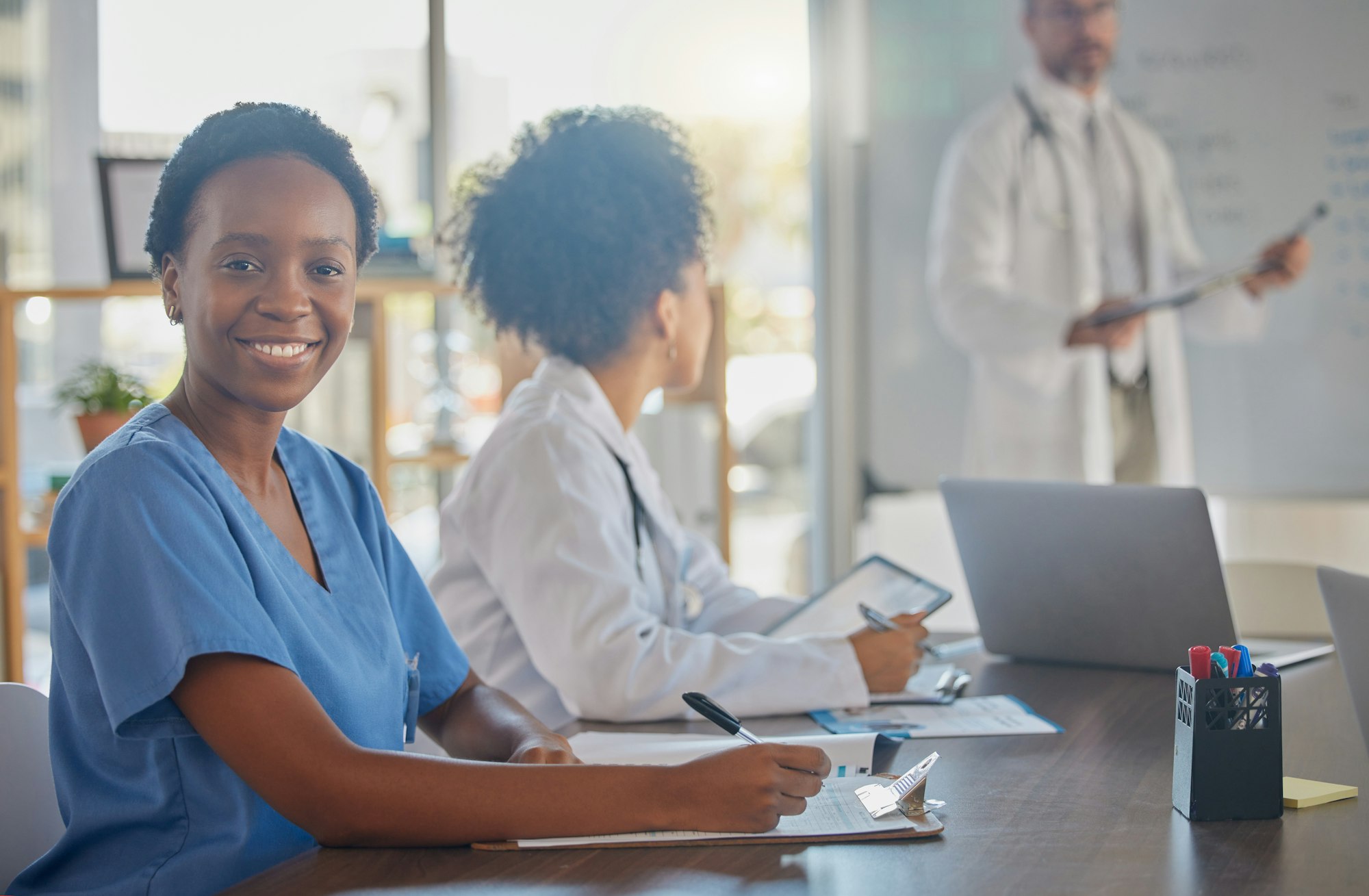 Medical meeting, portrait and African doctor writing notes in a nursing workshop for training at a